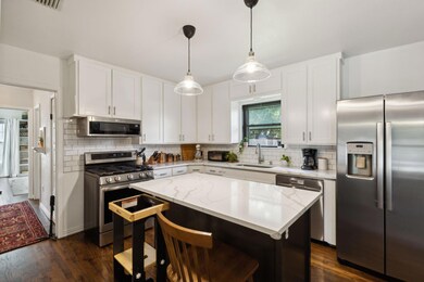 Kitchen featuring sink, white cabinetry, appliance