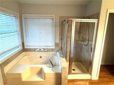 Bathroom featuring a bath, a stall shower, and wood finished floors