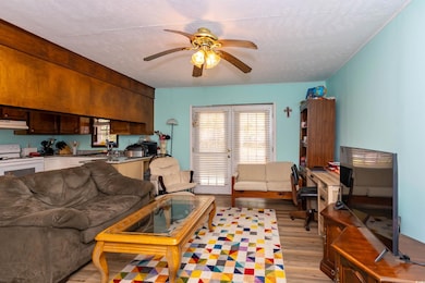 Living area with a textured ceiling, ceiling fan, 