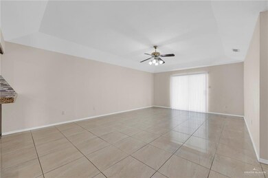 Spare room with light tile patterned floors, a ceiling fan, and a tray ceiling