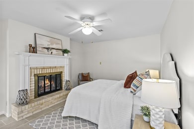 Bedroom with a fireplace, a ceiling fan, and tile
