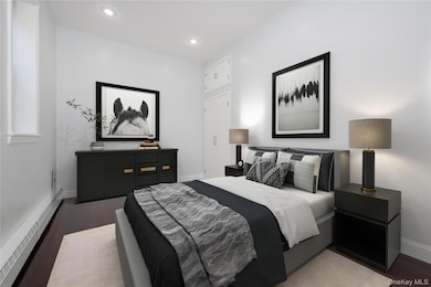 Bedroom featuring baseboard heating, dark wood-style flooring, and recessed lighting