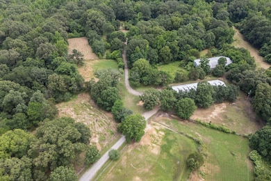 Aerial view of property and surrounding area featuring a forest