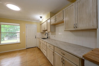 Kitchen featuring light brown cabinetry, a textur