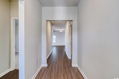 Hall featuring dark wood finished floors and baseb