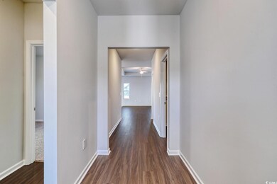 Hall featuring dark wood finished floors and baseb
