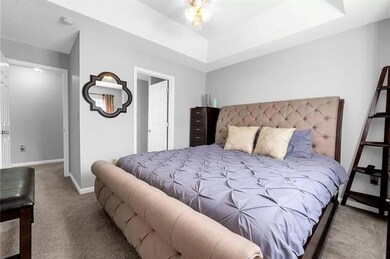 Comfortable bedroom with soft carpeting, raised ce
