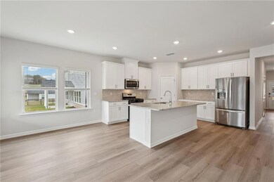 Kitchen featuring white cabinets, a sink, applianc