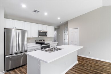 Kitchen with a center island with sink, stainless