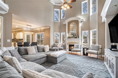 Living room with ceiling fan, light wood-type floo