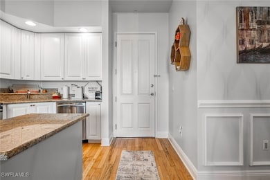 Kitchen with baseboards, light stone countertops,