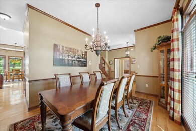 Dining room with crown molding, light wood-style flooring, a chandelier, and baseboards