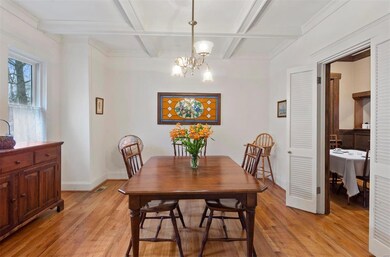 Spacious dining room with coffered ceiling adjoining breakfast room on right.