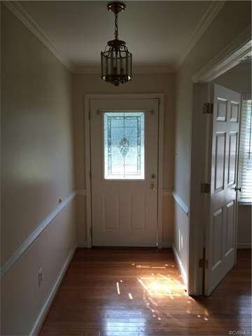 Foyer with decorative front door and hardwood floo