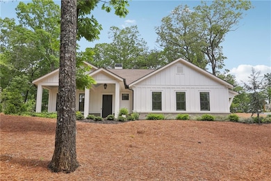 Modern inspired farmhouse with a chimney, board and batten siding, and roof with shingles
