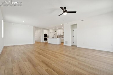 Unfurnished living room featuring ceiling fan, sin