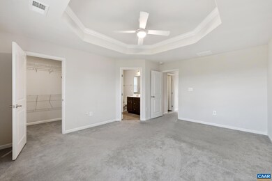 The spacious primary bedroom features a stylish tr