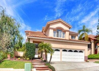 Home's entrance has grassy areas and brick-accente