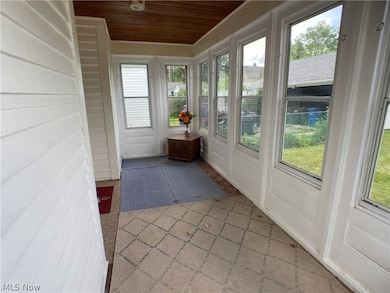 Unfurnished sunroom featuring a wealth of natural light and wood ceiling