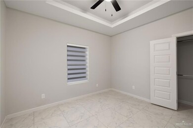 Unfurnished bedroom with light marble finish floors, a raised ceiling, and ceiling fan