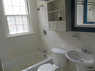 The bathroom features a newer toilet and pedestal sink.