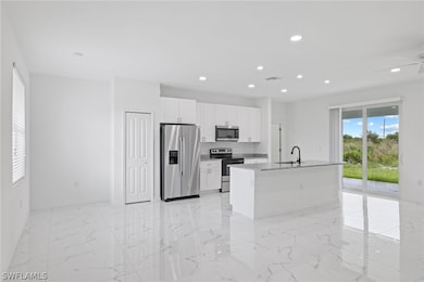 Kitchen with a kitchen island with sink, white cab