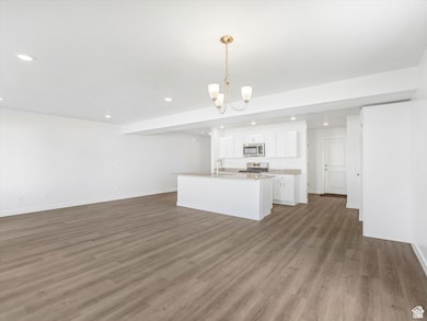 Kitchen featuring open floor plan, white cabinetry, pendant lighting, recessed lighting, and a chandelier