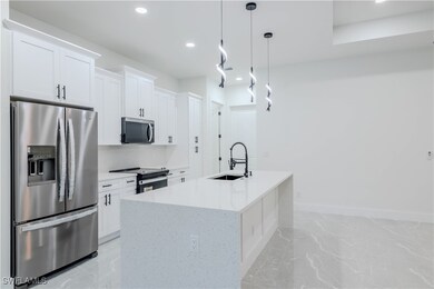 Kitchen with white cabinetry, recessed lighting, m