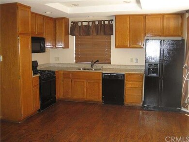 Open kitchen with hardwood floors, granite counter