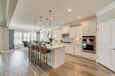 Kitchen with hanging light fixtures, custom range 