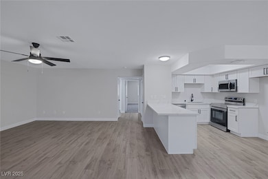 Kitchen with baseboards, visible vents, a sink, a