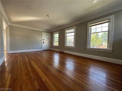 Spare room featuring dark hardwood / wood-style floors and crown molding