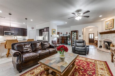 Tiled living room with a fireplace and ceiling fan
