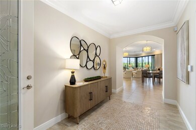 Hall featuring arched walkways, crown molding, bas