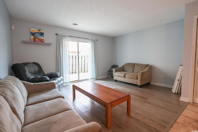 Living area with baseboards, a textured ceiling, a