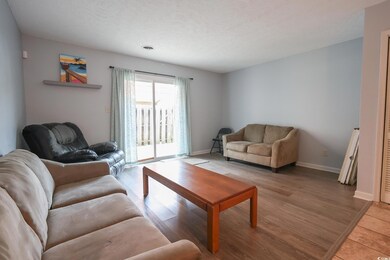 Living area with baseboards, a textured ceiling, a
