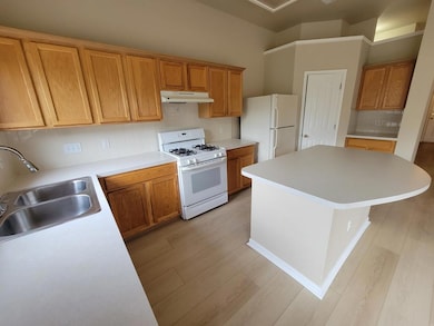 Kitchen with white appliances, light wood-style f