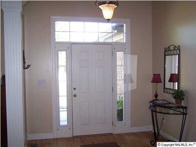 The foyer welcomes you home with transom window that lets natural light filter in.