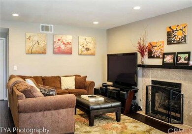 Spacious living room with cozy fireplace upon entr