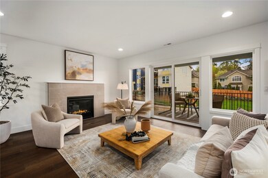 Great Room with Balcony Access: Sliding glass doors open to a covered outdoor patio, extending living space into the fresh Northwest air. Perfect for morning coffee or evening relaxation, this space enhances indoor-outdoor connection with a fully fenced backyard beyond.    Photos are from THIS model home at Foxmoore but are for visualization purposes only.  Photos are from the model home at Foxmoore and for visualization purposes only. Plans, colors, building orientation, finishes, home outlook, and other details can and WILL vary.