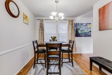 Dining room with chandelier and light wood-style f