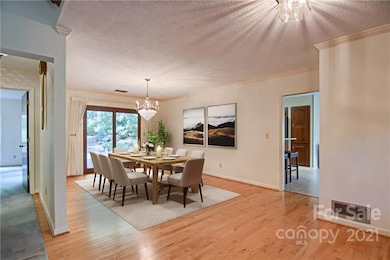 Large Dining Room and Hardwood Floors.  Note- The Chandelier Does Not Convey.staged for photos