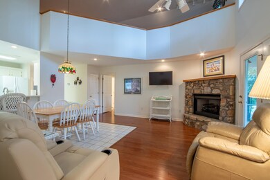 Living room featuring ceiling fan, a fireplace, ha