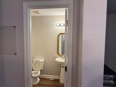 Bathroom with a textured ceiling, hardwood / wood-