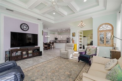 Living room featuring coffered ceiling, ceiling fa
