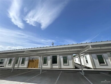 Back of house with a metal roof and covered parking