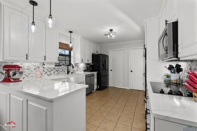 Kitchen with white cabinets, black appliances, and