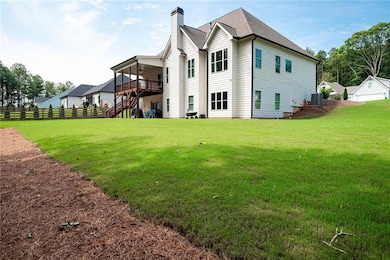 Back of property with a lawn, central AC unit, and