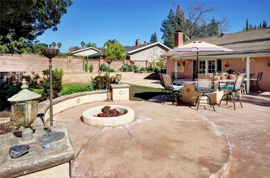 Additional patio area features fire pit and stamped concrete near BBQ area and separate side yard.