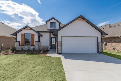 View of front of home featuring a garage, concrete driveway, a front lawn, and brick siding